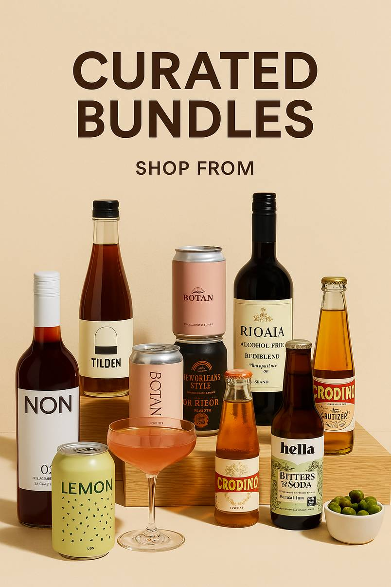 A curated selection of non-alcoholic drinks including red wine, botanical spritzers, and cocktail-inspired beverages arranged with a cocktail glass and snack bowl on a beige background.